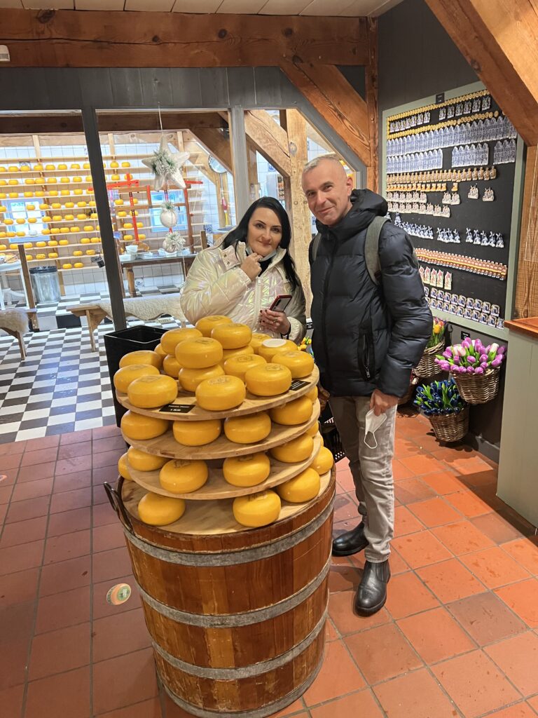 buying Dutch cheese — tourists choosing Gouda wheels on a farm tour